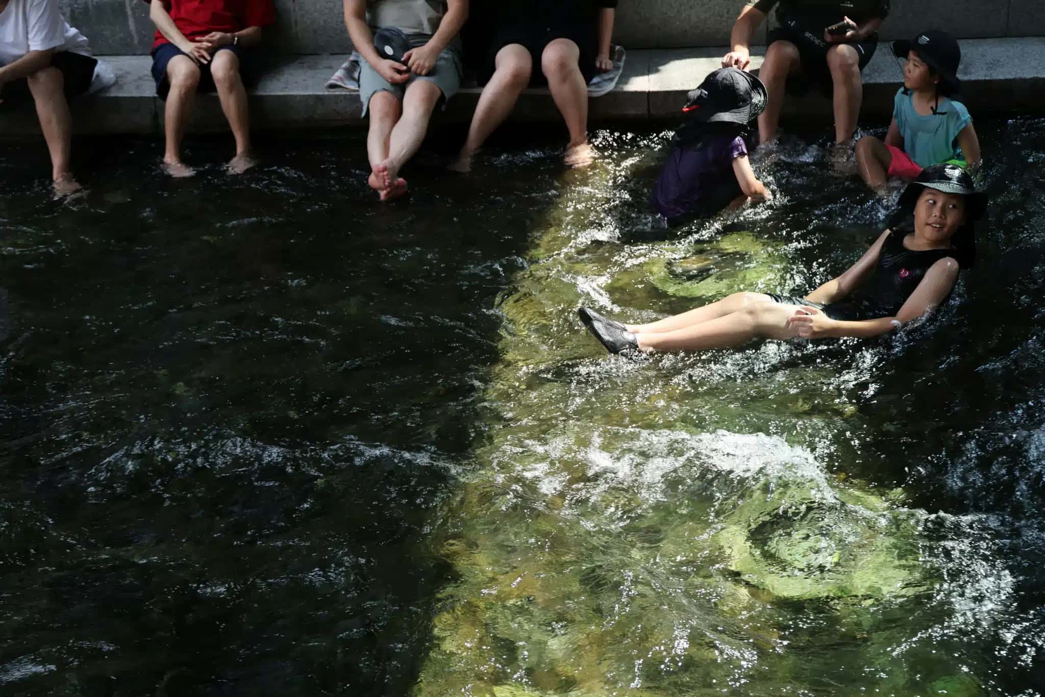 Crianças brincam na água para se refrescar na Coreia do Sul 3 de agosto de 2026